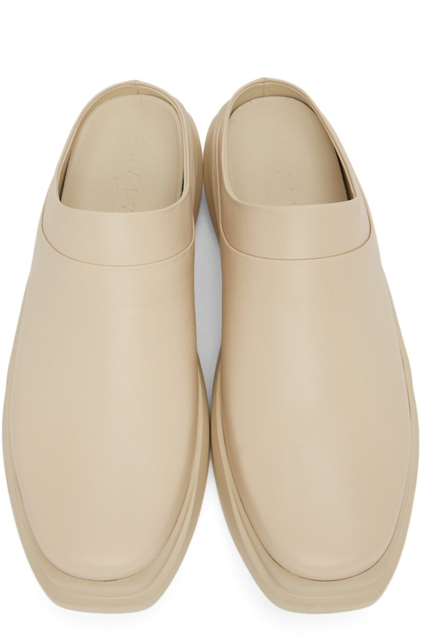 Buffed leather slip-on loafers in beige. 

· Square toe
· Logo embossed at heel counter and footbed
· Sculpted foam rubber midsole
· Treaded rubber outsole

Supplier color: Sand