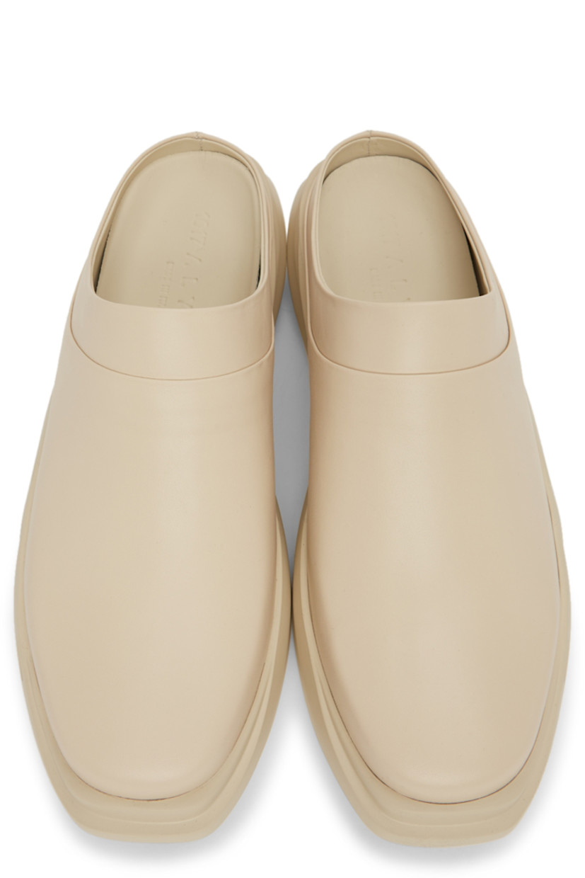 Buffed leather slip-on loafers in beige. 

· Square toe
· Logo embossed at heel counter and footbed
· Sculpted foam rubber midsole
· Treaded rubber outsole

Supplier color: Sand