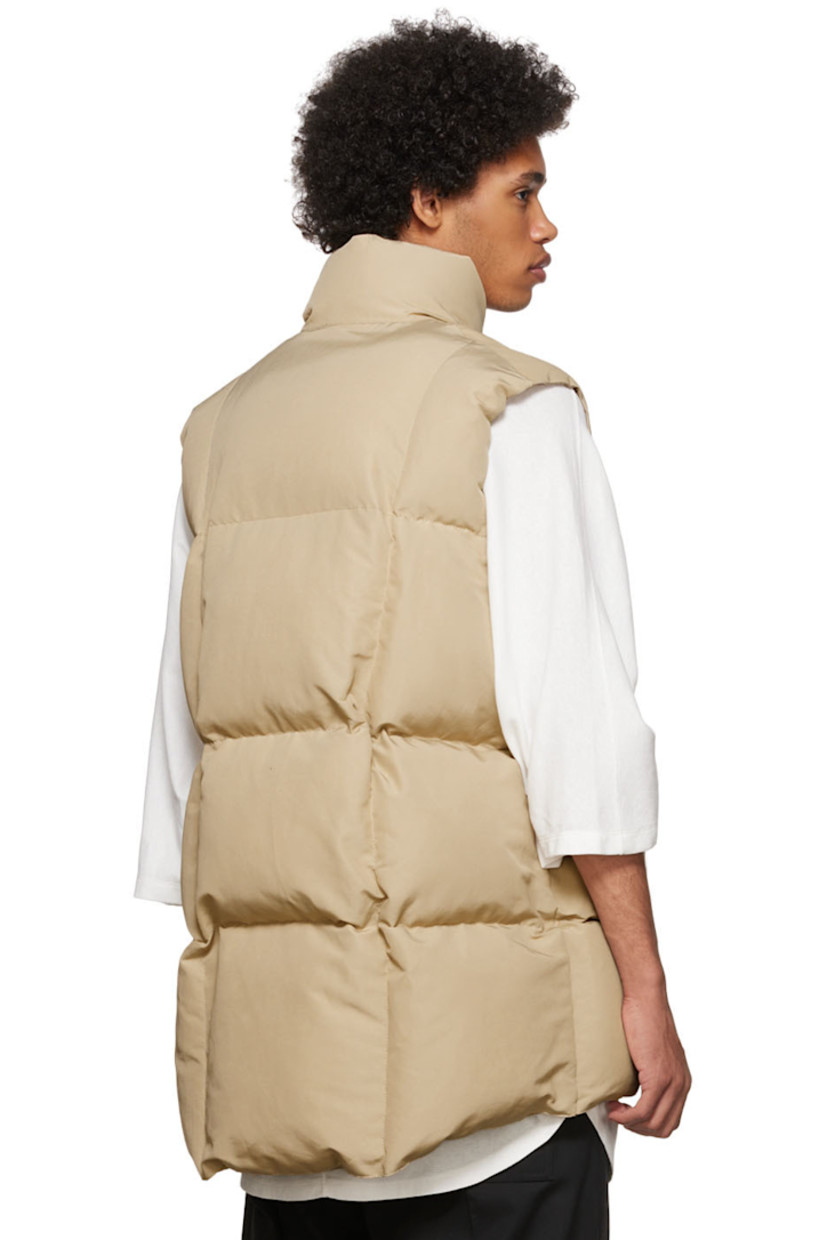 Primaloft® insulated quilted plain woven cotton and nylon-blend vest.

· Stand collar
· Button closure
· Straps and vinyl trim at transparent vinyl patch pockets
· Concealed drawstring at waist
· Nylon ripstop lining
· Logo-engraved silver-tone hardware

Supplier color: Beige