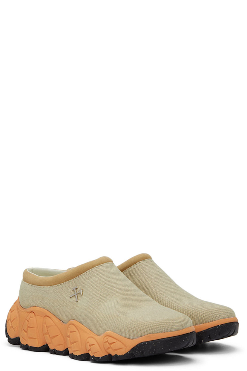 Low-top canvas slip-on sneakers in beige.

· Padded faux-suede tongue and collar 
· Logo hardware at side 
· Leather lining in white 
· Sculptural foam rubber midsole in orange
· Treaded Vibram® rubber outsole 

Supplier color: Tan
