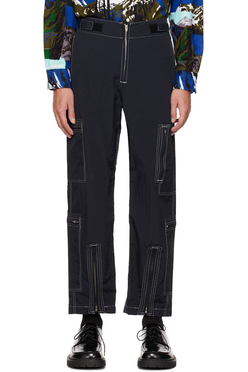 Nylon faille cargo pants. 

· Concealed drawstring at elasticized waistband
· Adjustable velcro straps at front waistband
· Four-pocket styling
· Zip-fly
· Zip extension panel at cuffs
· Zip pockets at outseams
· Contrast stitching in white

Supplier color: Black