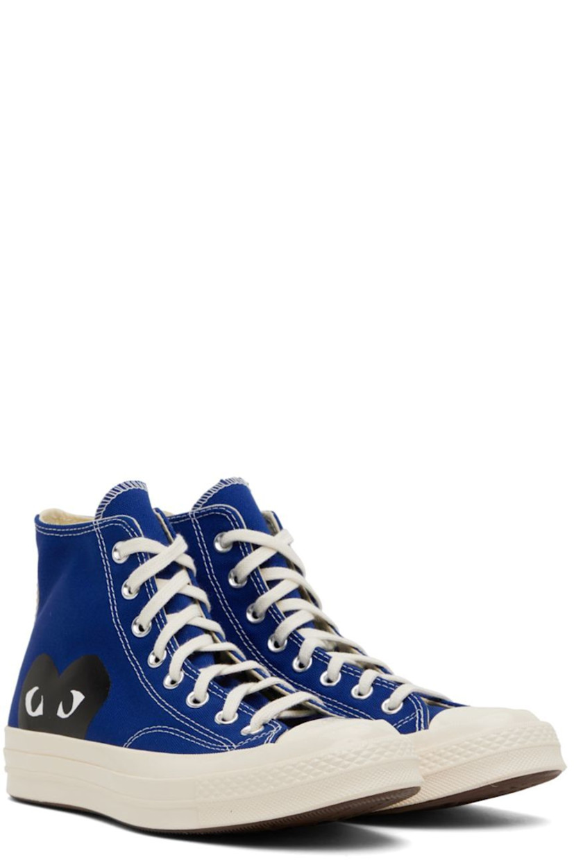 High-top canvas sneakers in blue. Logo graphic printed at outer side. 

· Round rubber cap toe 
· Lace-up closure 
· Logo bonded at inner side
· Webbing trim in off-white at heel
· Ortholite® footbed 
· Rubber midsole in off-white with logo embossed at heel
· Treaded rubber outsole in brown
· Contrast stitching in white 

Part of the Comme des Garçons Play x Converse collaboration.

Supplier color: Blue