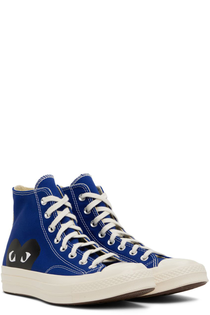High-top canvas sneakers in blue. Logo graphic printed at outer side. 

· Round rubber cap toe 
· Lace-up closure 
· Logo bonded at inner side
· Webbing trim in off-white at heel
· Ortholite® footbed
· Rubber midsole with logo embossed at heel
· Treaded rubber outsole in brown
· Contrast stitching in white 

Part of the Comme des Garçons Play x Converse collaboration.

Supplier color: Blue