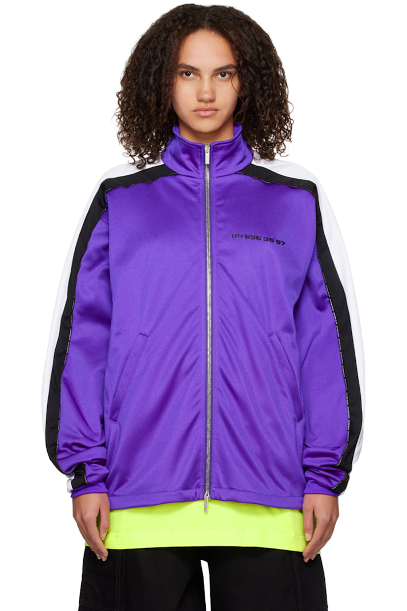 Nylon-blend jersey track jacket.

· Stand collar
· Two-way zip closure
· Text bonded at chest
· Concealed zip pockets
· Concealed bungee-style drawstring at hem
· Dropped shoulders
· Text-woven piping  and striped trim at sleeves
· Rib knit cuffs
· Rubberized graphic patch at back collar
· Full mesh lining

Supplier color: Purple/Black