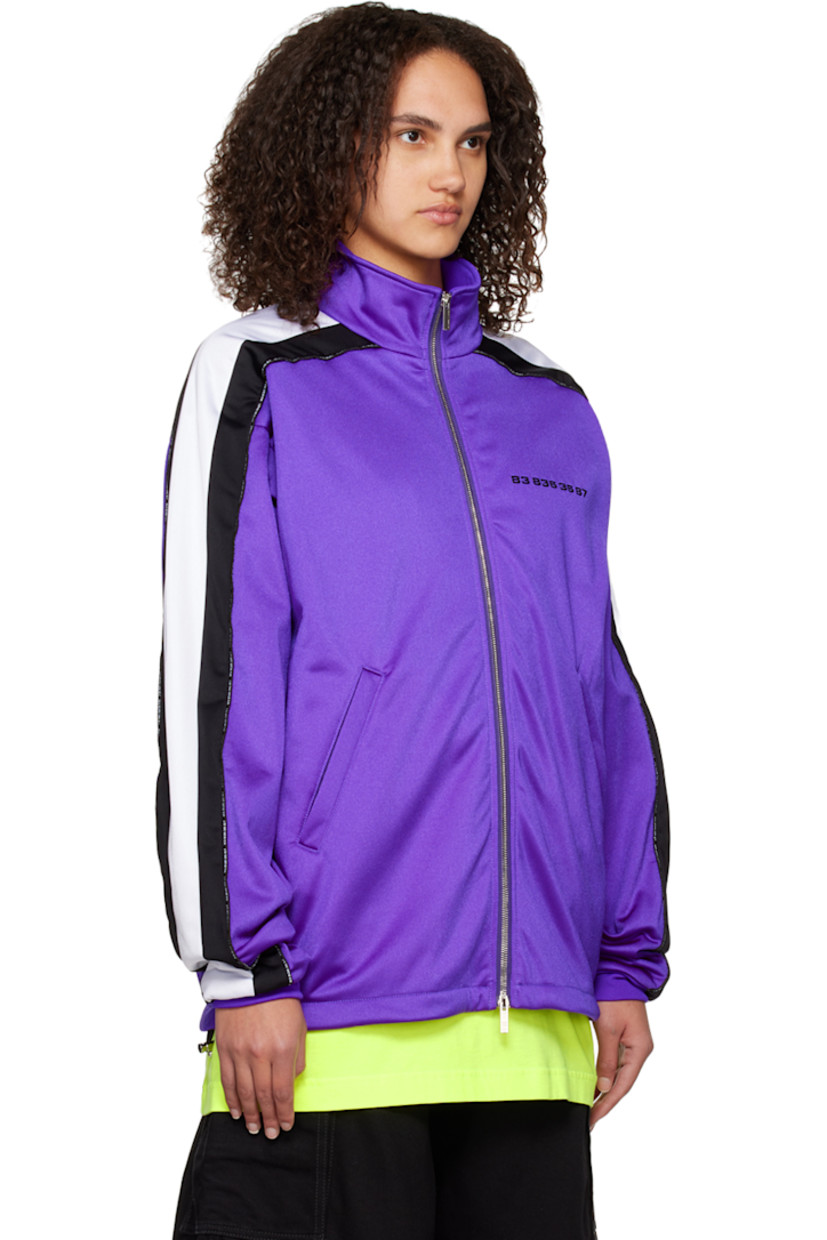Nylon-blend jersey track jacket.

· Stand collar
· Two-way zip closure
· Text bonded at chest
· Concealed zip pockets
· Concealed bungee-style drawstring at hem
· Dropped shoulders
· Text-woven piping  and striped trim at sleeves
· Rib knit cuffs
· Rubberized graphic patch at back collar
· Full mesh lining

Supplier color: Purple/Black