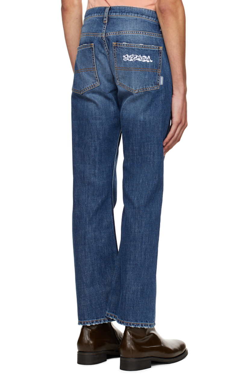 Non-stretch denim jeans. Distressing throughout. 

· Belt loops
· Five-pocket styling
· Zip-fly
· Logo graphic embroidered at back
· Rubberized logo flag at back
· Logo-engraved silver-tone hardware
· Contrast stitching in tan

Supplier color: Blue denim