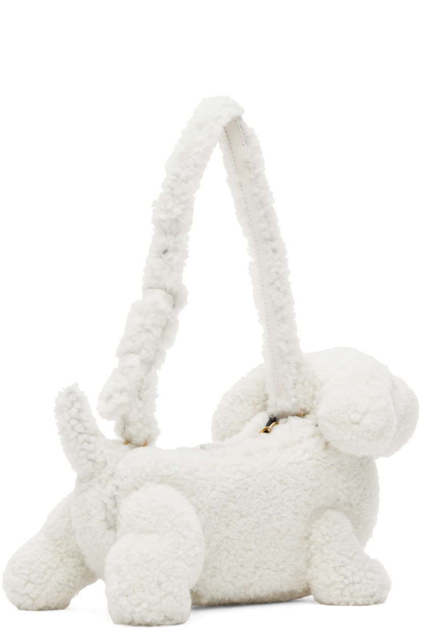 Sculptural Merino shearling shoulder bag in white. Grained calfskin trim in black throughout.

· Rolled carry handle
· Zip closure
· Patch pocket at interior
· Signature tricolor twill lining
· Logo-engraved gold-tone hardware
· H9 x W14 x D6 in

Supplier color: White