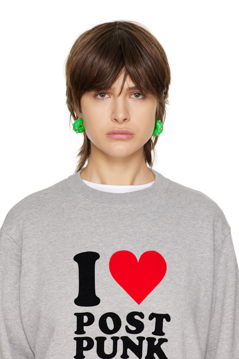 Pair of enameled open hoop earrings in green. Enameled pink studs throughout. 

· Post-stud fastening 
· Palladium-plated brass hardware
· D1"

Supplier color: Green