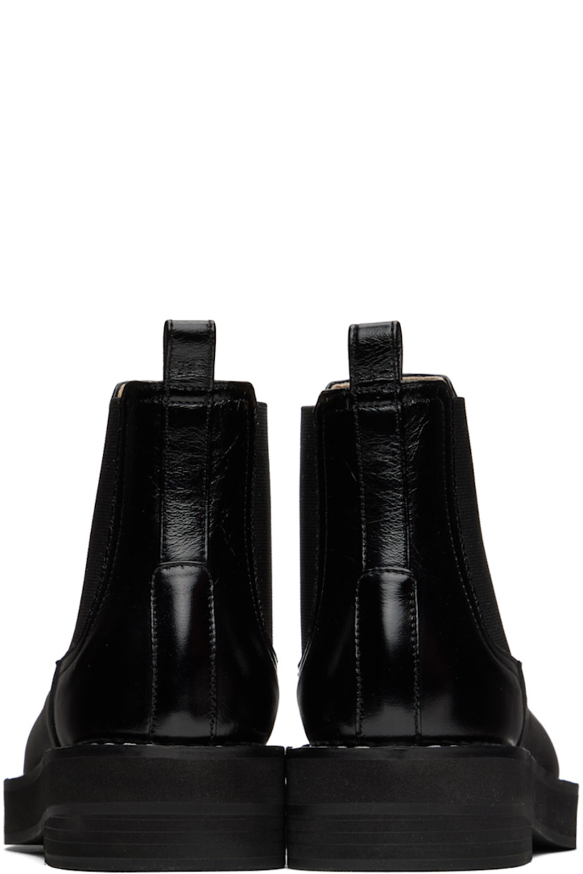Ankle-high buffed leather boots in black. 

· Pull-loop at heel collar
· Elasticized gussets at sides
· Topstitching at welt
· Foam rubber midsole
· Rubber outsole

Wholesale exclusivity at SSENSE.

Supplier color: Black