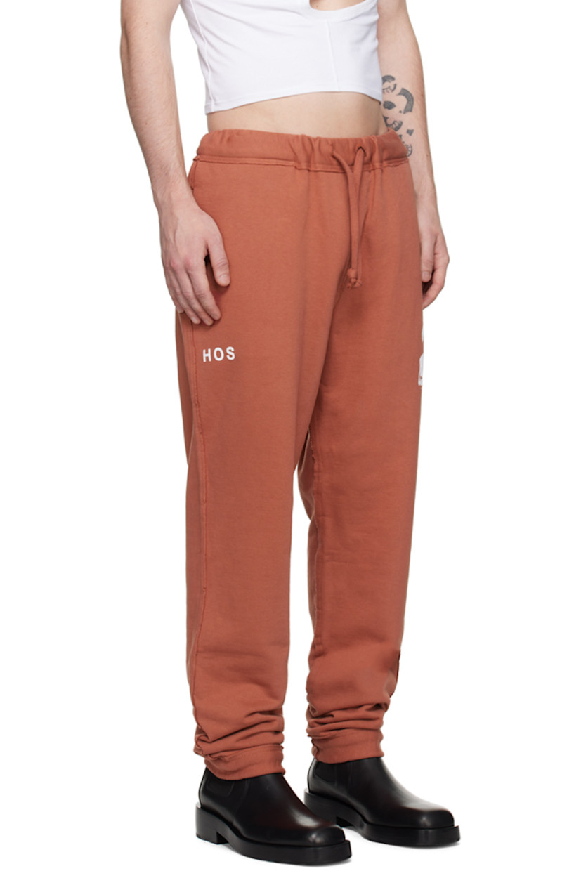 Cotton-blend French terry lounge pants.

· Drawstring at elasticized waistband
· Two-pocket styling
· Graphic and text printed at front
· Raw edge at inseams and outseams
· Elasticized cuffs

Supplier color: Brown