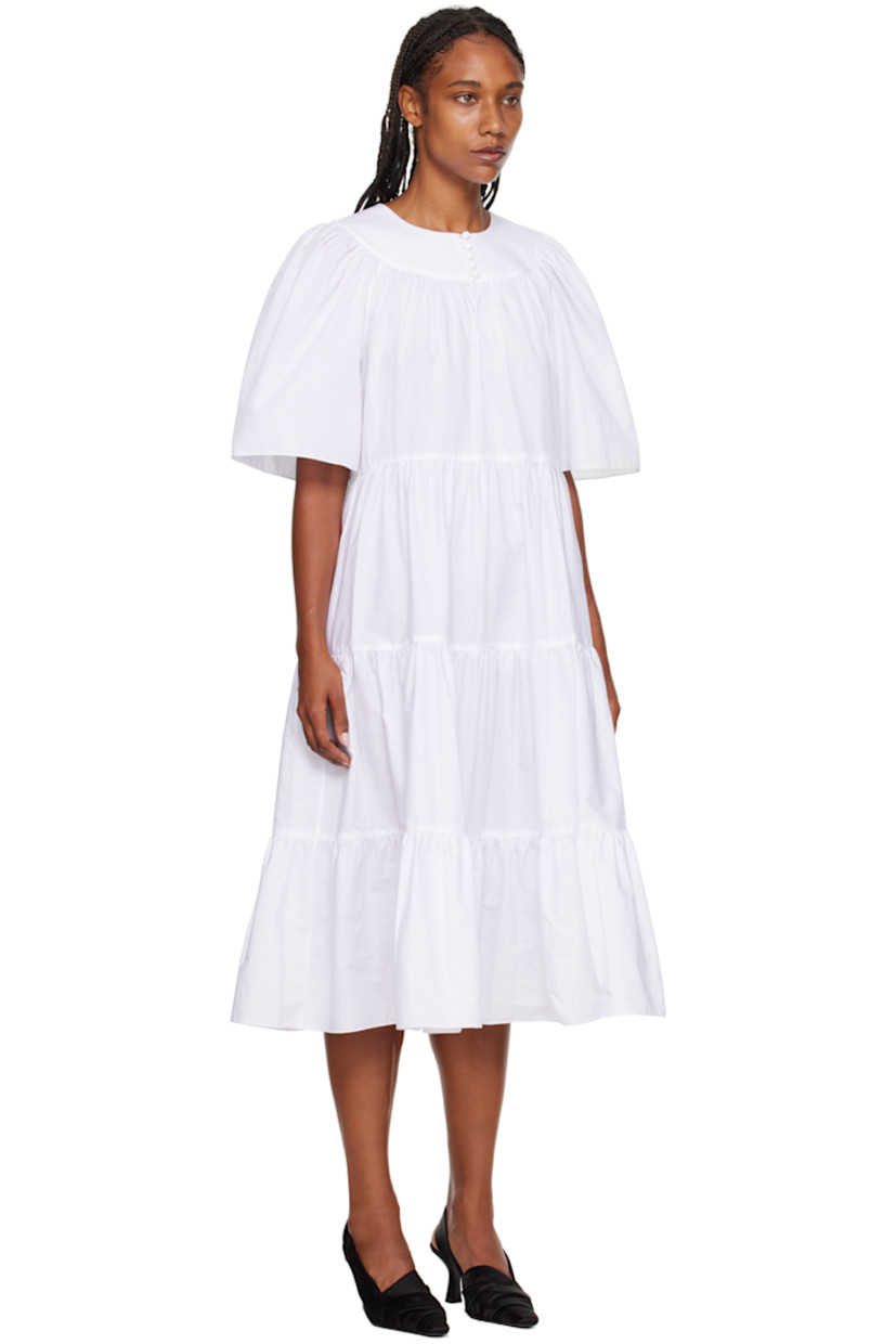 BCI and GOTS-certified organic cotton poplin dress. 

· Tiered construction 
· Crewneck
· Five-button placket 
· Cutout at chest 
· Welt pockets 
· Raglan sleeves 

Supplier color: White