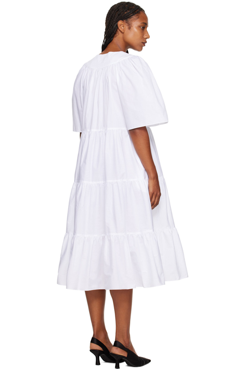 BCI and GOTS-certified organic cotton poplin dress. 

· Tiered construction 
· Crewneck
· Five-button placket 
· Cutout at chest 
· Welt pockets 
· Raglan sleeves 

Supplier color: White