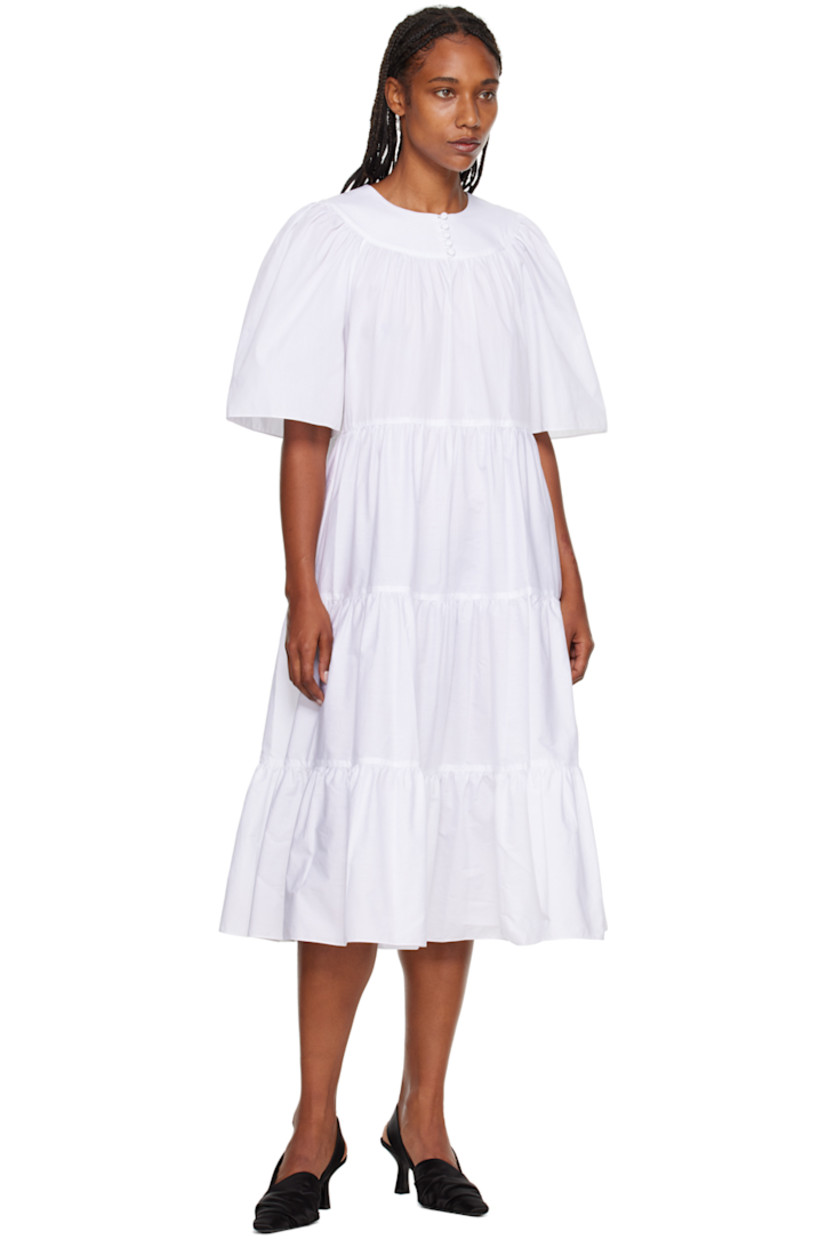 BCI and GOTS-certified organic cotton poplin dress. 

· Tiered construction 
· Crewneck
· Five-button placket 
· Cutout at chest 
· Welt pockets 
· Raglan sleeves 

Supplier color: White