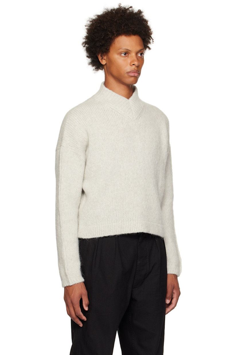 Knit virgin wool- and alpaca-blend sweater. 

· Rib knit V-neck, hem, and cuffs
· Cropped hem 
· Dropped shoulders 
· Logo patch at back 

Supplier color: Stone