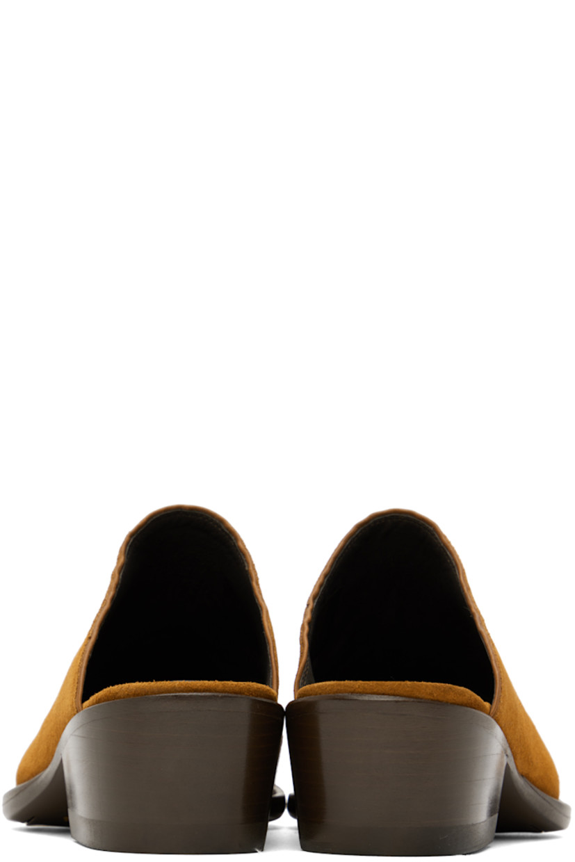 Suede mules in tan. 

· Pointed toe 
· Graphic stitched at vamp
· Gold-tone logo stamp at leather footbed 
· Buffed leather lining in brown
· Stacked leather heel with rubber injection
· Leather sole 
· Heel: H2 in 

Supplier color: Brown