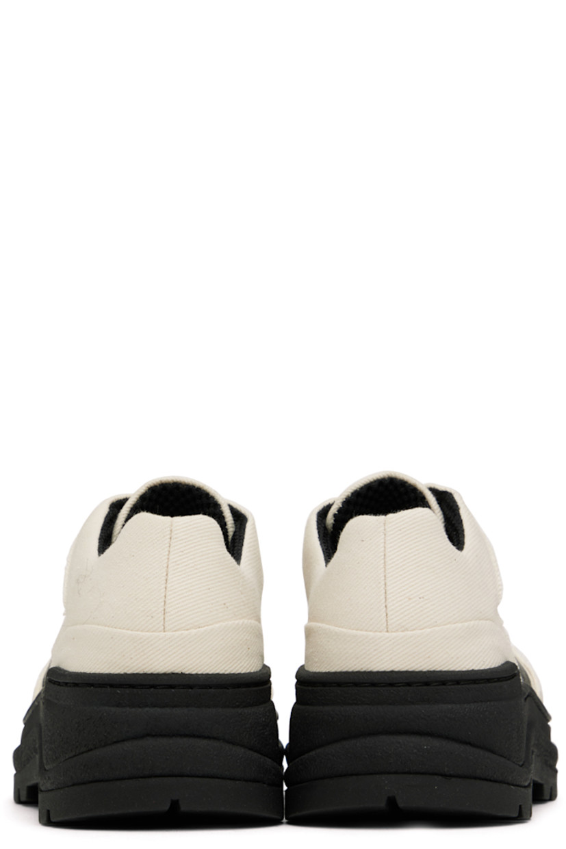 Low-top canvas sneakers in off-white and black.

· Lace-up closure
· Padded tongue and collar
· Logo bonded at outer side
· Logo embroidered at inner side
· Mesh lining in black
· Rubber midsole
· Treaded rubber outsole

Supplier color: Ecru