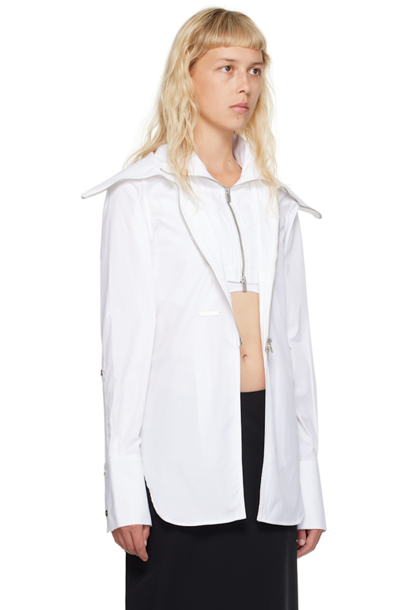 Heavyweight organic cotton poplin shirt. 

· Layered construction
· Spread collar 
· Concealed two-way half-zip closure 
· Two-way zip closure 
· Logo plaque at front 
· Shirttail hem
· Press-stud tab at cuffs 
· Adjustable press-release strap at back
· Logo-engraved silver-tone hardware

Supplier color: White