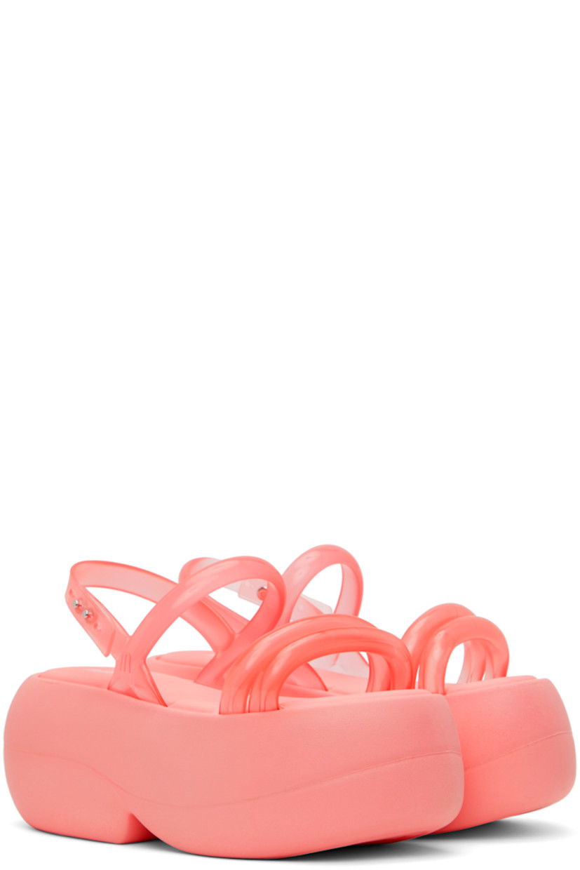 Transparent Melflex® PVC sandals in pink.

· Open round toe
· Padded straps at vamp
· Adjustable slingback strap
· Grenflex® padded rubber footbed
· Treaded EVA foam rubber sole
· Platform: H3 in

Supplier color: Pink