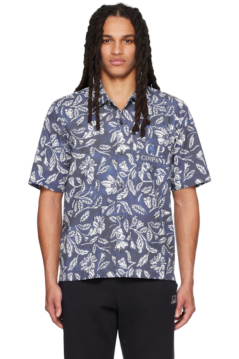 Garment-dyed cotton poplin shirt. Floral pattern and logo printed throughout. 

· Spread collar
· Button closure
· Patch pocket
· Logo-engraved black hardware

Supplier color: Medieval blue
