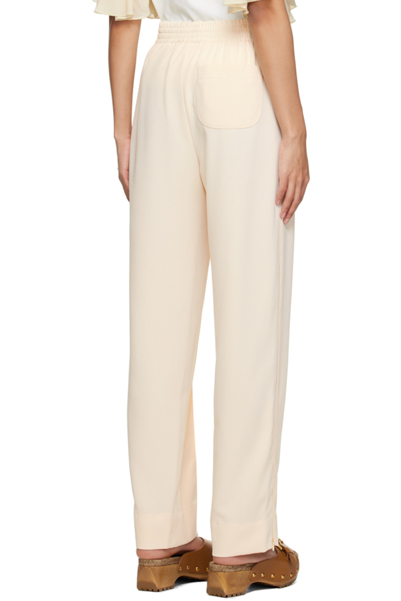Polyester crepe trousers. 

· Concealed drawstring at elasticized waistband
· Three-pocket styling
· Pinched seams at front 
· Zip vent at cuffs 
· Piping at outseams 

Supplier color: Ivory