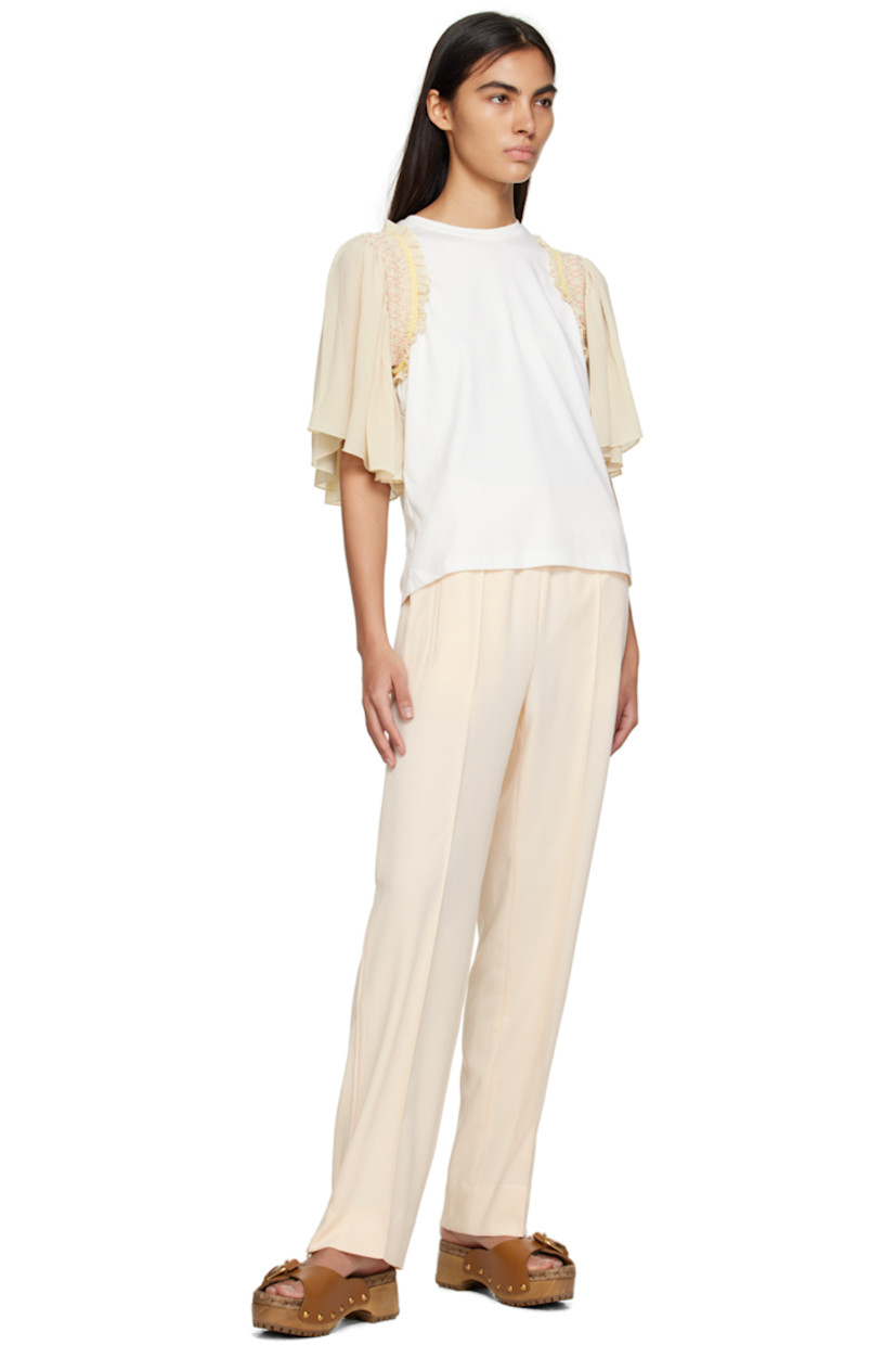 Polyester crepe trousers. 

· Concealed drawstring at elasticized waistband
· Three-pocket styling
· Pinched seams at front 
· Zip vent at cuffs 
· Piping at outseams 

Supplier color: Ivory