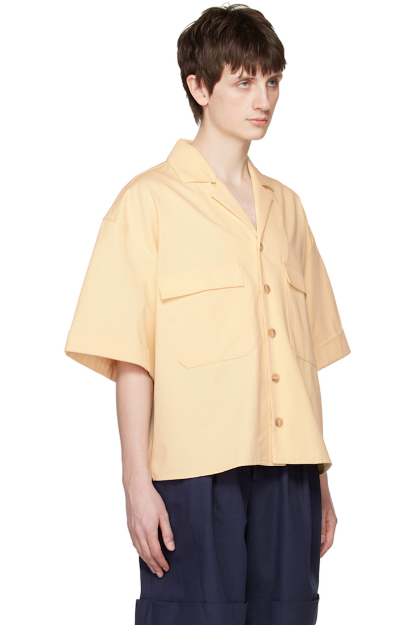 Cotton twill shirt.

· Open spread collar
· Button closure
· Patch pockets 
· Vented side seams
· Rolled edge at cuffs
· Box pleat at back yoke

Supplier color: Ecru