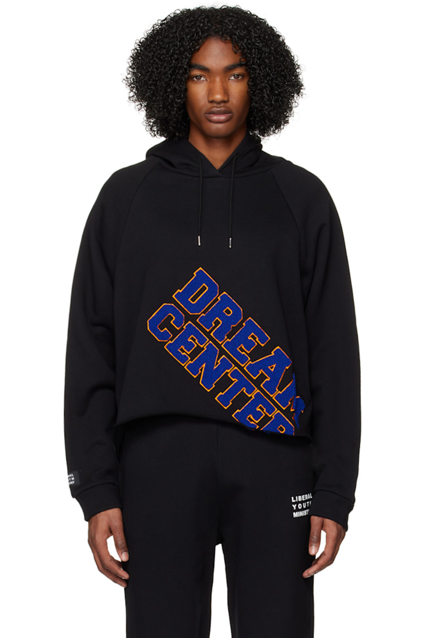 French terry hoodie.

· Drawstring at hood
· Chenille patches at front
· Raw edge at asymmetric hem
· Raglan sleeves
· Logo patch at cuff
· Rib knit cuffs

Supplier color: Black