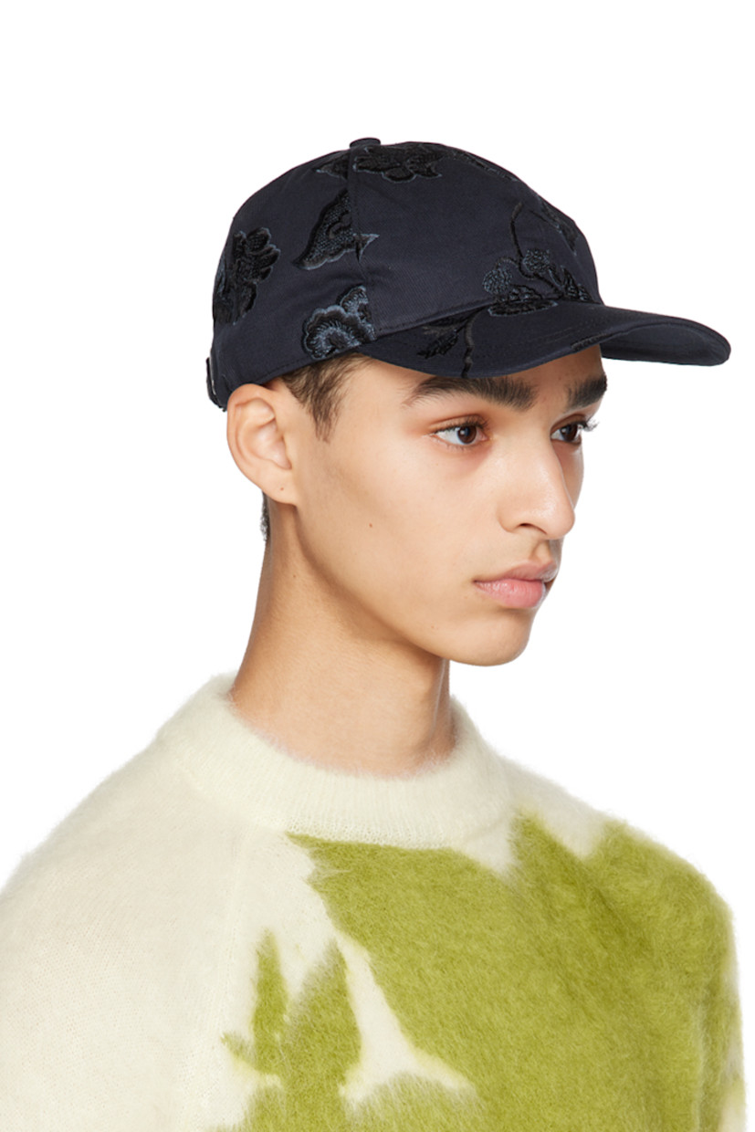 Cotton twill cap in navy. Floral pattern embroidered throughout. 

· Curved brim
· Adjustable cinch strap at back face
· Grosgrain browband
· Cotton twill lining

Supplier color: Navy