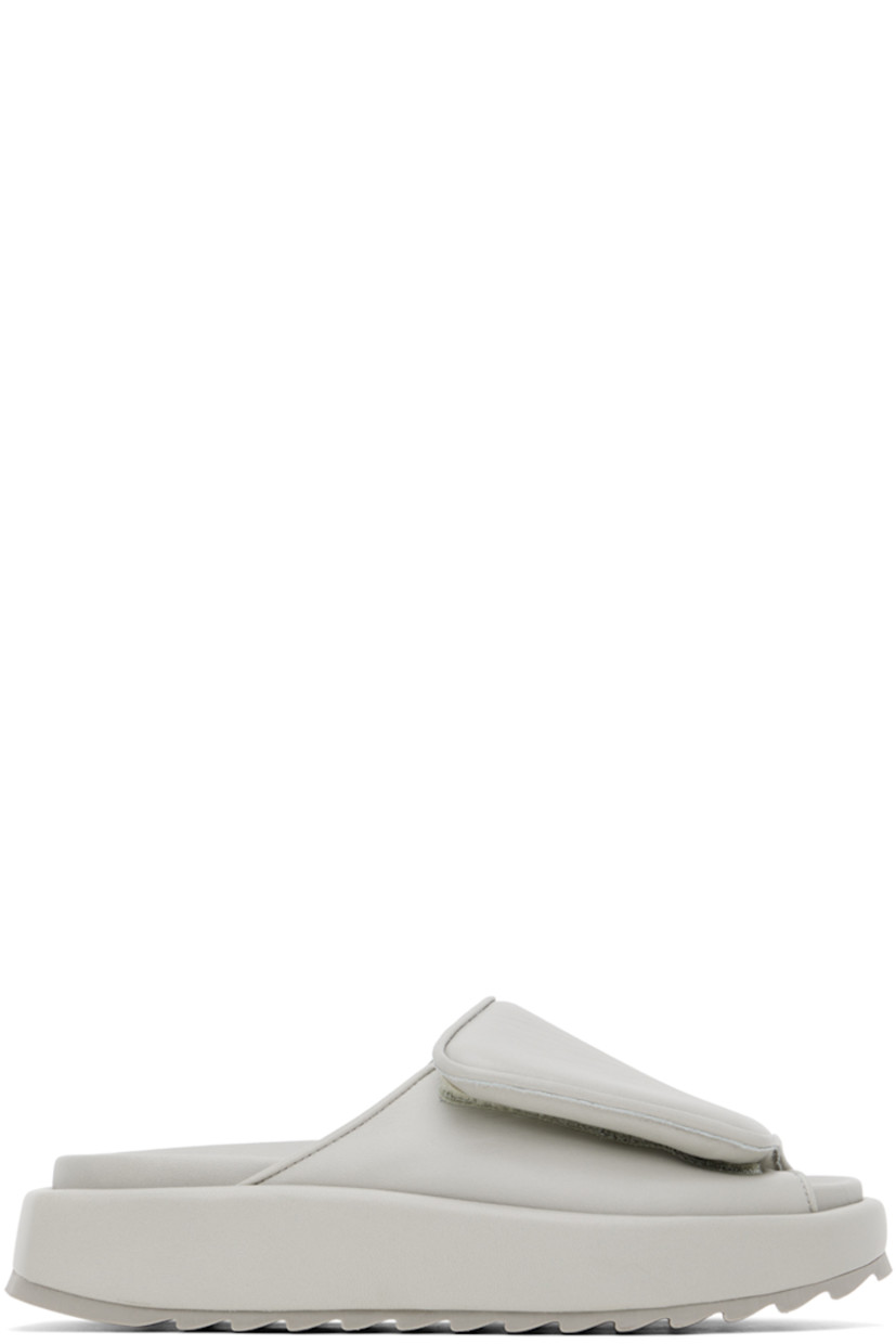 Buffed leather slip-on sandals in gray. 

· Open round toe
· Padded velcro strap at vamp
· Logo embossed at molded footbed
· Covered platform midsole
· Treaded rubber outsole
· Platform: H1.5 in

Supplier color: Stone grey