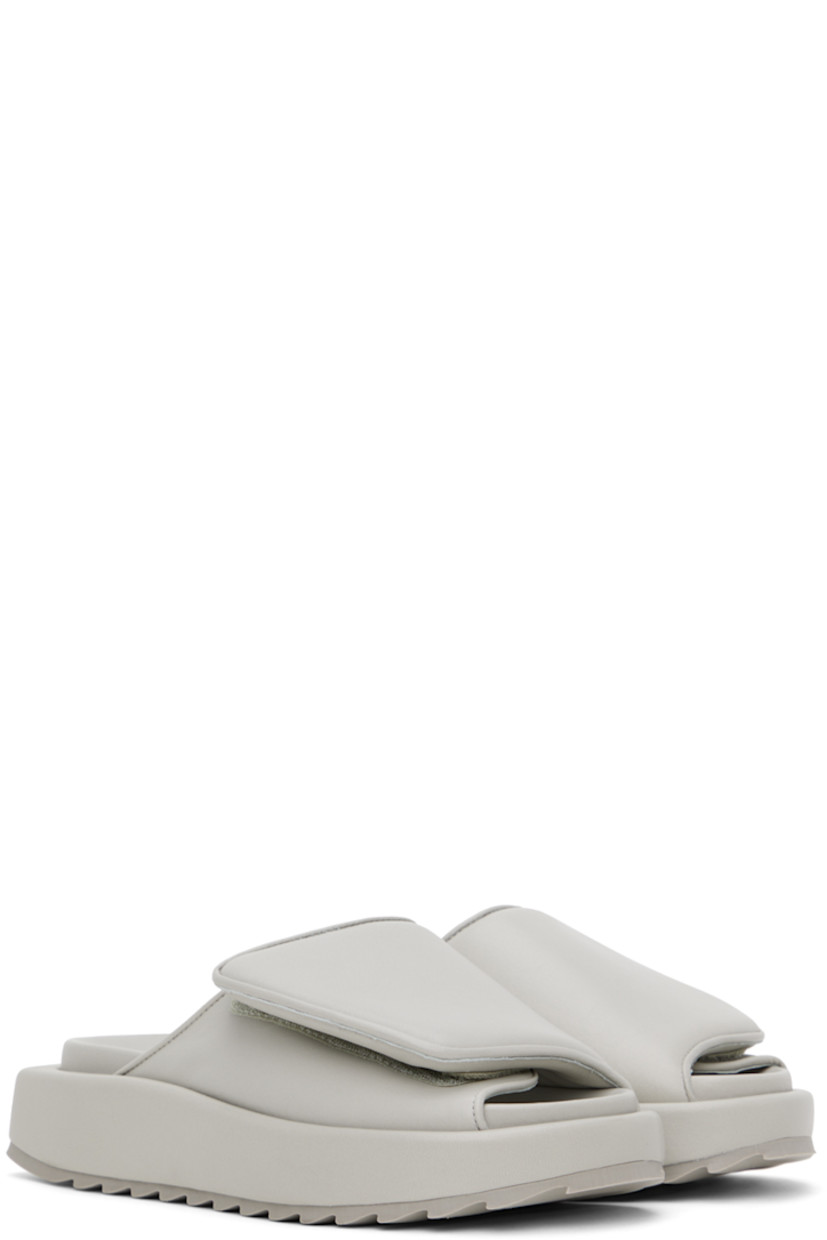 Buffed leather slip-on sandals in gray. 

· Open round toe
· Padded velcro strap at vamp
· Logo embossed at molded footbed
· Covered platform midsole
· Treaded rubber outsole
· Platform: H1.5 in

Supplier color: Stone grey