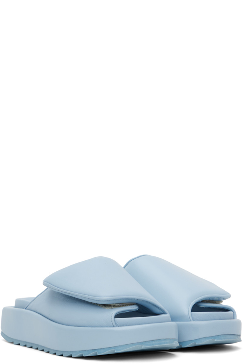 Buffed leather slip-on sandals in blue. 

· Open round toe
· Padded velcro strap at vamp
· Logo embossed at molded footbed
· Covered platform midsole
· Treaded rubber outsole
· Platform: H1.5 in

Supplier color: Ice blue