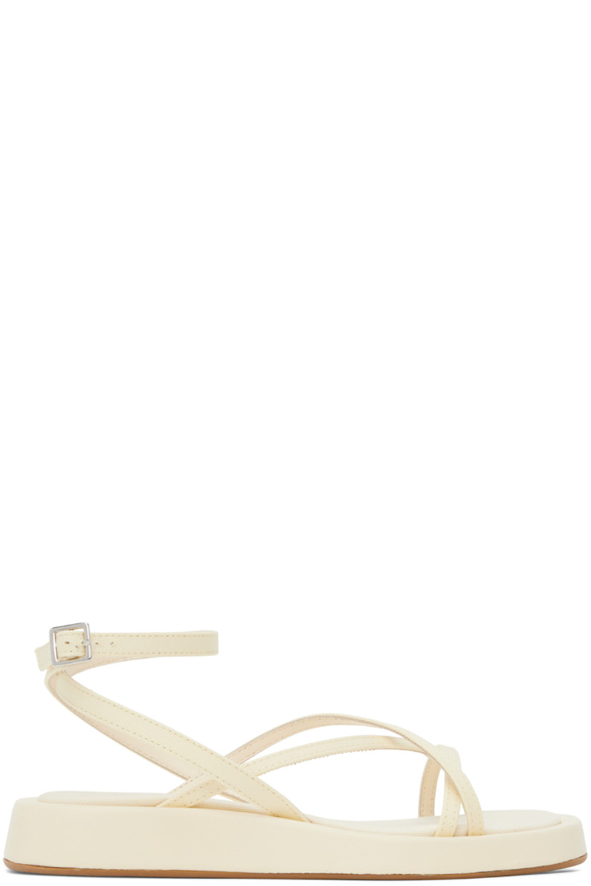 Canvas sandals in off-white.

· Open square toe
· Criss-crossing straps at vamp
· Wraparound pin-buckle ankle strap
· Logo patch at canvas footbed
· Leather-covered midsole
· Rubber outsole

Supplier color: Cream