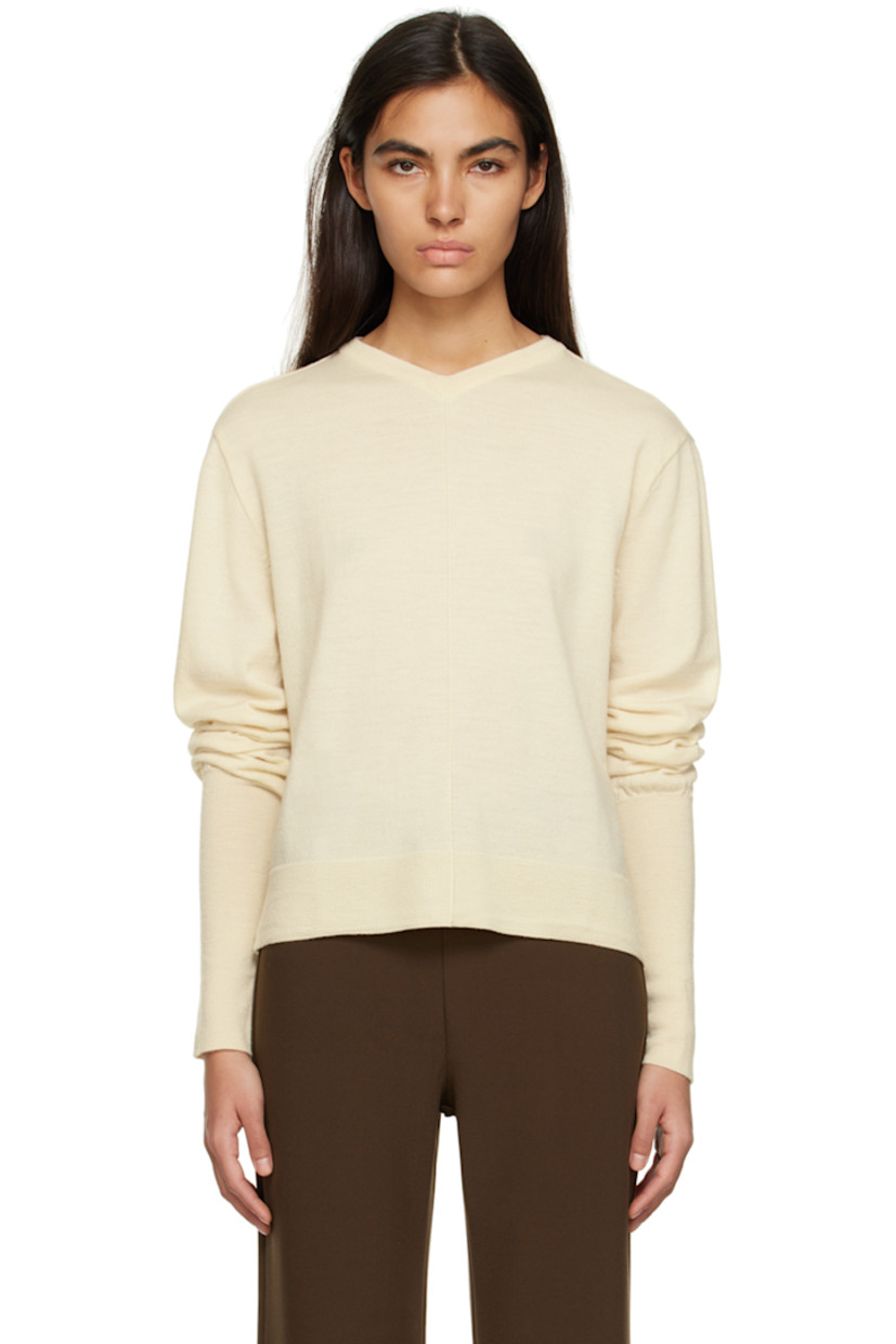 Knit wool sweater. 

· Rib knit V-neck, hem, and cuffs
· Pinched seams at front
· Cutout at back 

Supplier color: Ivory