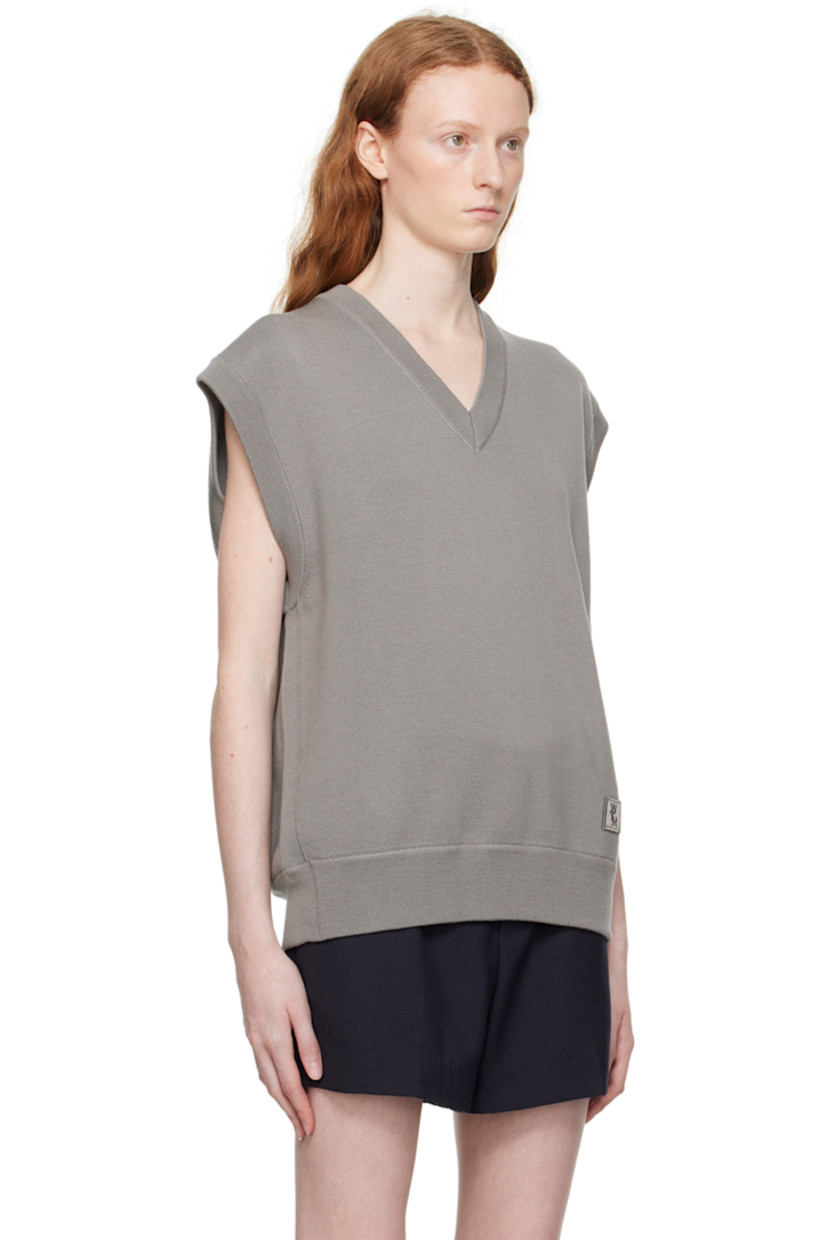 Knit wool vest.

· Rib knit V-neck, hem, and armscyes 
· Embroidered logo patch at hem 
· Leather logo patch at back collar 

Supplier color: Gray