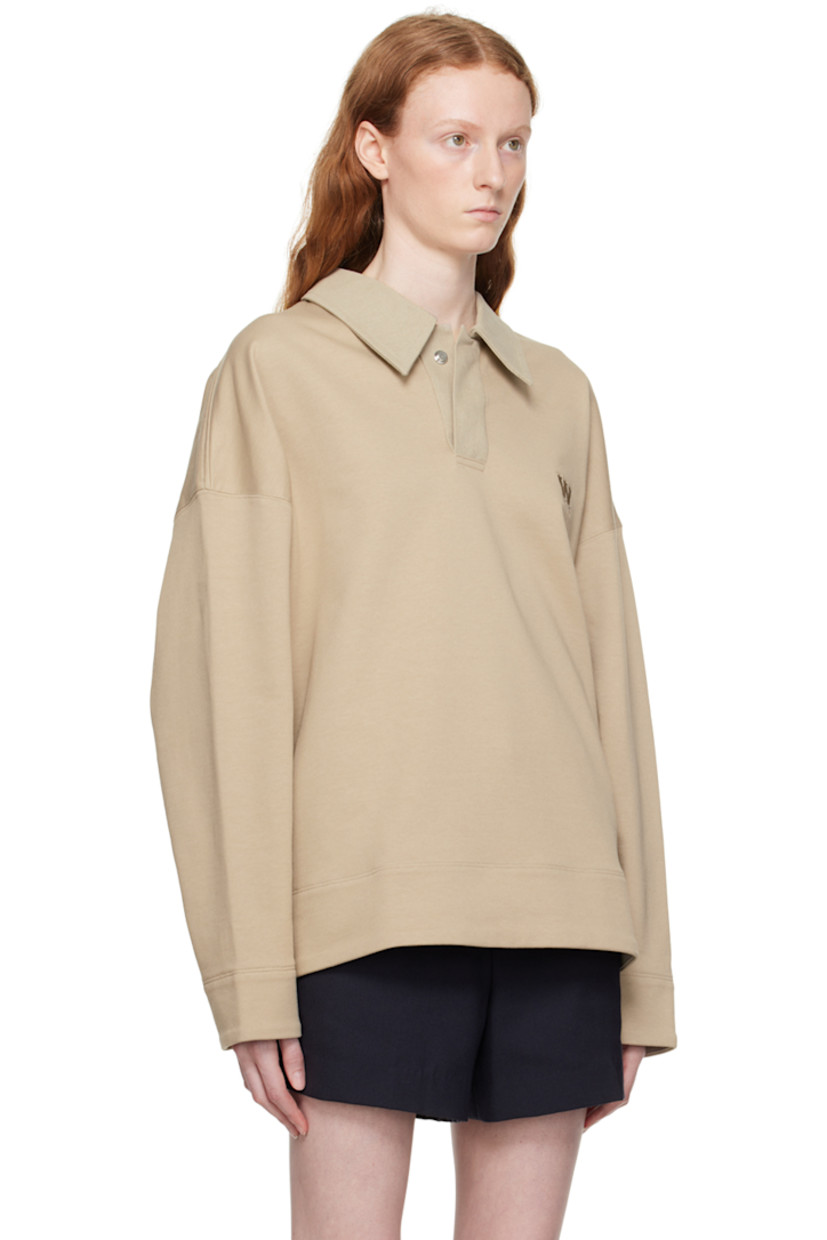 French terry polo. 

· Cotton canvas spread collar
· Two-press-stud placket
· Logo embroidered at chest 
· Vented side seams
· Logo hardware at back collar 

Supplier color: Beige