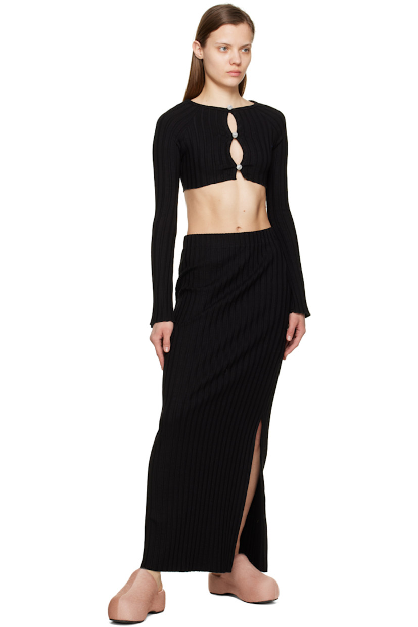 Stretch rib knit viscose cardigan.

· Boat neck
· Button closure
· Lettuce edge at hem and cuffs
· Raglan sleeves

Supplier color: Black