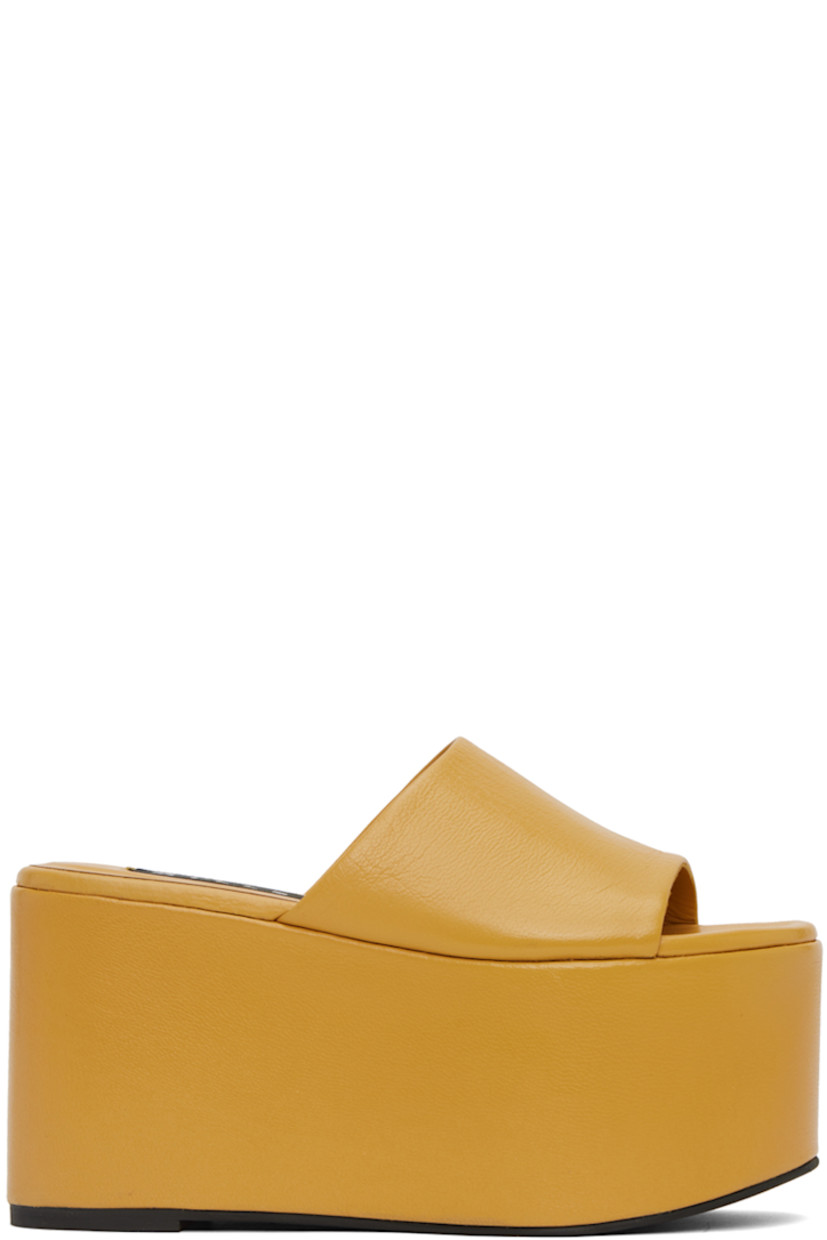 Grained goat leather sandals in yellow.

· Open round toe
· Strap at vamp
· Textile logo patch at padded leather footbed
· Leather-covered cork platform
· Rubber outsole
· Platform: H4 in

Supplier color: Butter