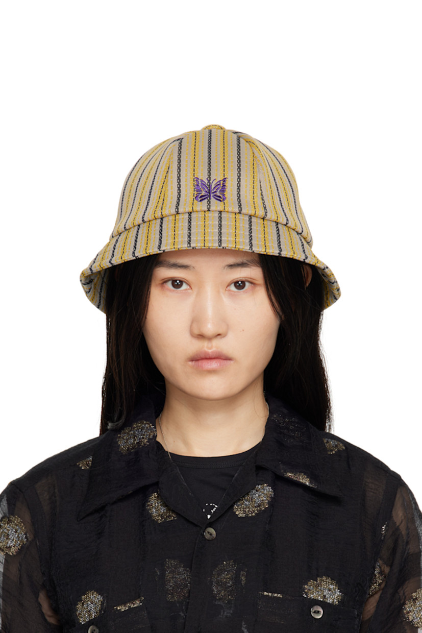 Polyester jersey bucket hat in gray and yellow. Stripes throughout.

· Graphic embroidered at face
· Quilted brim
· Full mesh lining

Supplier color: D-Stripe