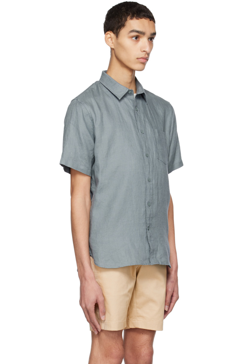 Plain-woven linen shirt. 

· Spread collar
· Button closure
· Patch pocket
· Shirttail hem
· Box pleat at back yoke

Supplier color: Teal pool