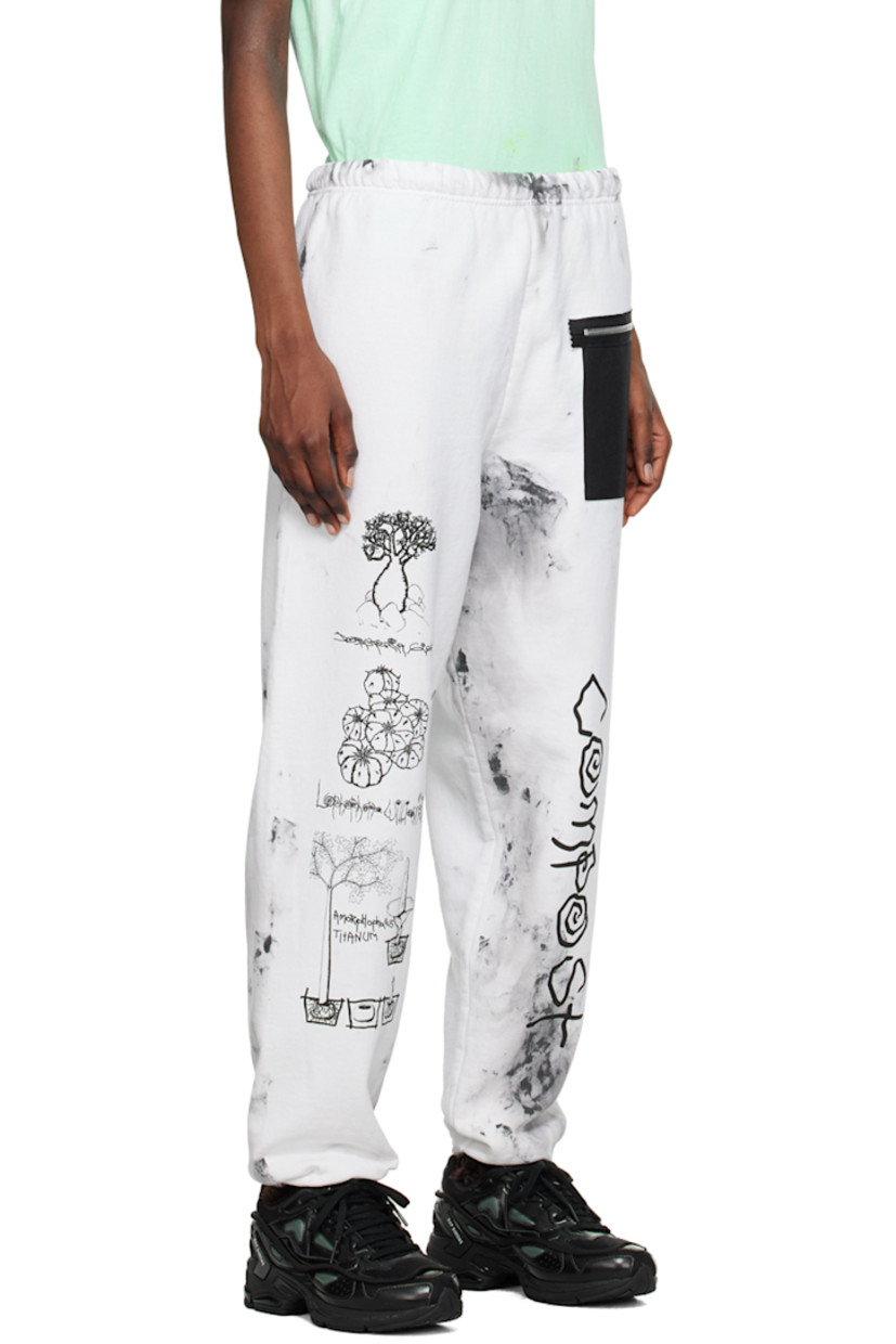 Cotton- and polyester-blend fleece lounge pants. Smudging throughout. 

· Concealed drawstring at elasticized waistband
· Canvas zip pocket at front
· Graphics and text printed at legs
· Elasticized cuffs

Each item is unique. Please note that coloration and finishing may vary.

Supplier color: Dirty white