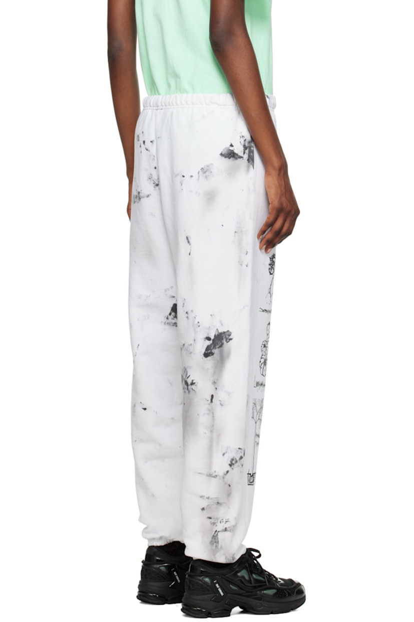 Cotton- and polyester-blend fleece lounge pants. Smudging throughout. 

· Concealed drawstring at elasticized waistband
· Canvas zip pocket at front
· Graphics and text printed at legs
· Elasticized cuffs

Each item is unique. Please note that coloration and finishing may vary.

Supplier color: Dirty white