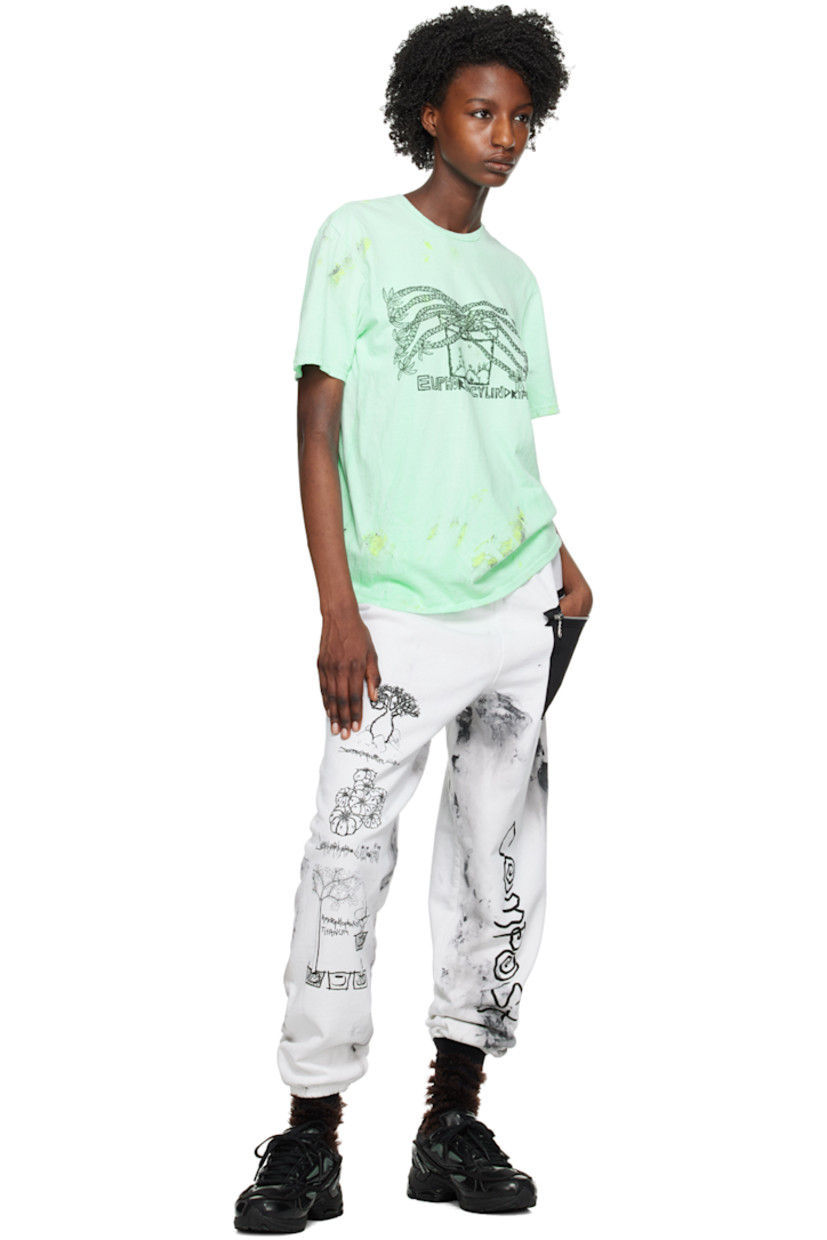 Cotton- and polyester-blend fleece lounge pants. Smudging throughout. 

· Concealed drawstring at elasticized waistband
· Canvas zip pocket at front
· Graphics and text printed at legs
· Elasticized cuffs

Each item is unique. Please note that coloration and finishing may vary.

Supplier color: Dirty white