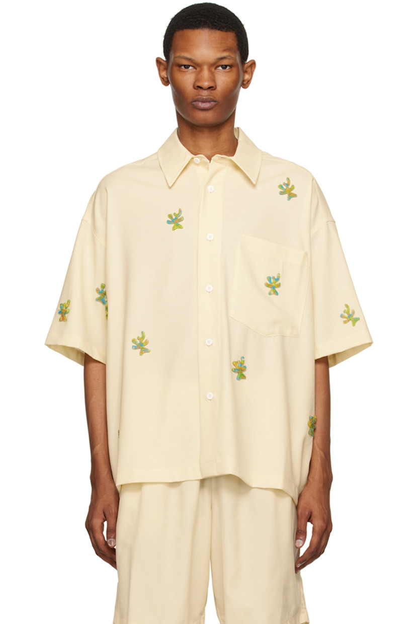 Stretch virgin wool twill shirt. Graphic appliqués throughout.

· Spread collar
· Button closure
· Patch pocket
· Cropped hem
· Dropped shoulders
· Inverted pleat at back yoke 

Supplier color: Ivory