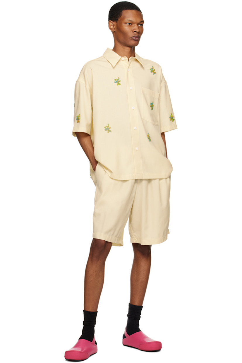 Stretch virgin wool twill shirt. Graphic appliqués throughout.

· Spread collar
· Button closure
· Patch pocket
· Cropped hem
· Dropped shoulders
· Inverted pleat at back yoke 

Supplier color: Ivory