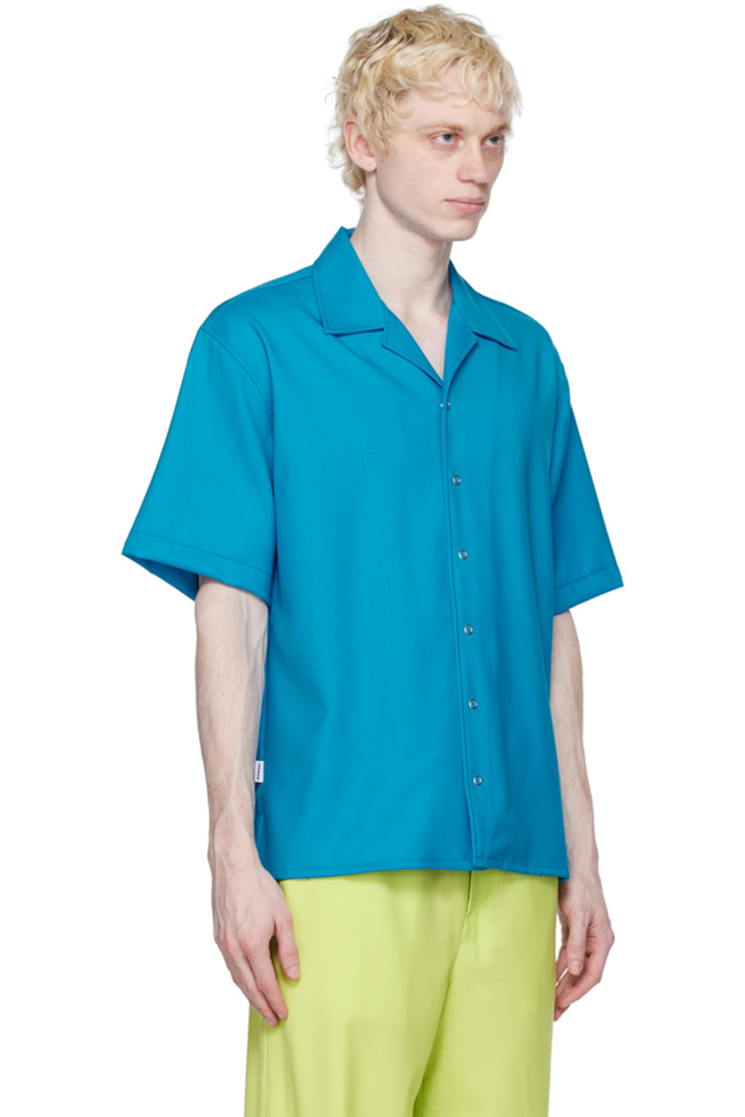 Stretch virgin wool twill shirt.

· Open spread collar
· Press-stud closure
· Logo flag at side seam
· Vented side seams
· Dropped shoulders

Supplier color: Azure