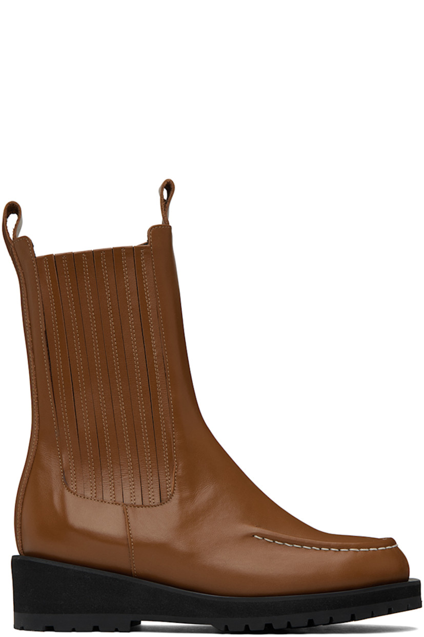 Calf-high buffed leather boots in brown.

· Moc toe
· Pull-loops at collar
· Elasticized gusset at outer side
· Zip closure at inner side
· Foam rubber platform midsole
· Treaded rubber outsole
· Heel: H1.75 in

Supplier color: Brown