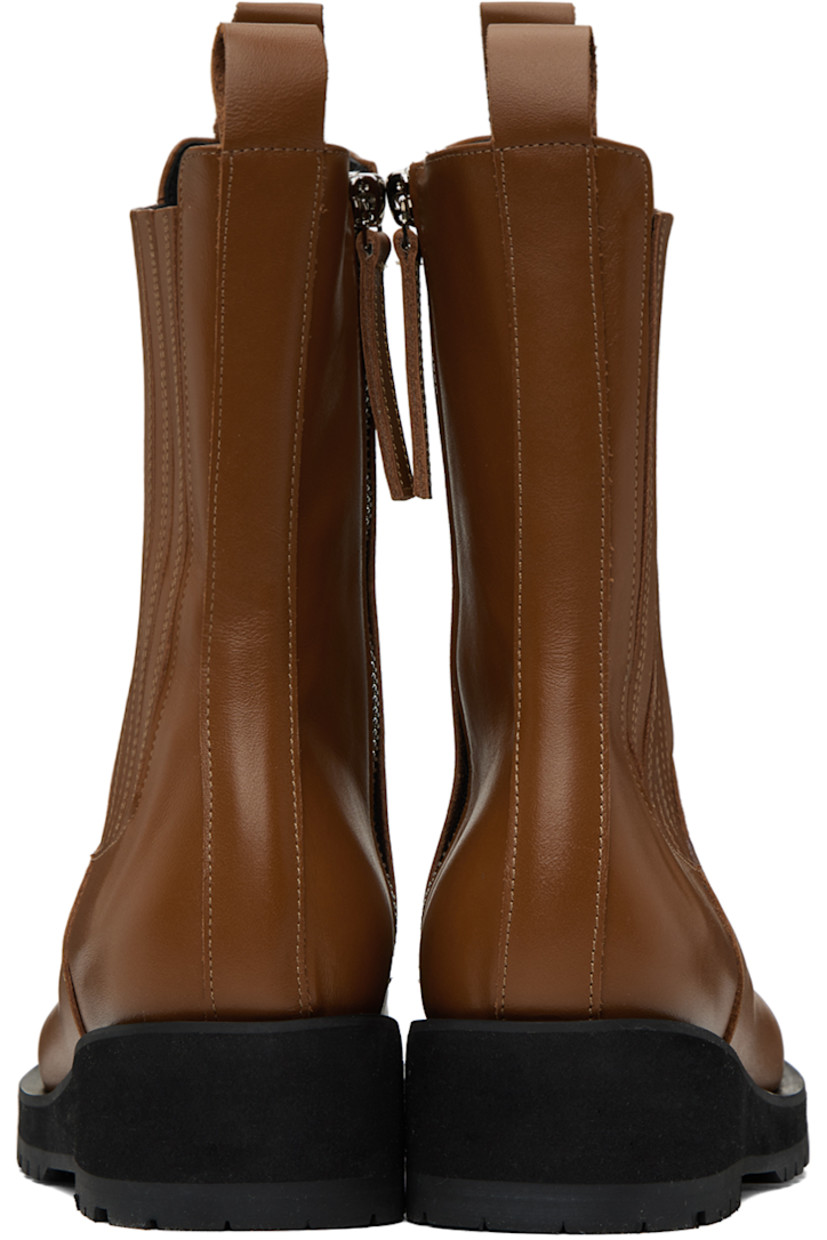 Calf-high buffed leather boots in brown.

· Moc toe
· Pull-loops at collar
· Elasticized gusset at outer side
· Zip closure at inner side
· Foam rubber platform midsole
· Treaded rubber outsole
· Heel: H1.75 in

Supplier color: Brown