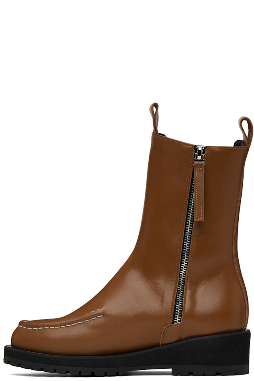Calf-high buffed leather boots in brown.

· Moc toe
· Pull-loops at collar
· Elasticized gusset at outer side
· Zip closure at inner side
· Foam rubber platform midsole
· Treaded rubber outsole
· Heel: H1.75 in

Supplier color: Brown