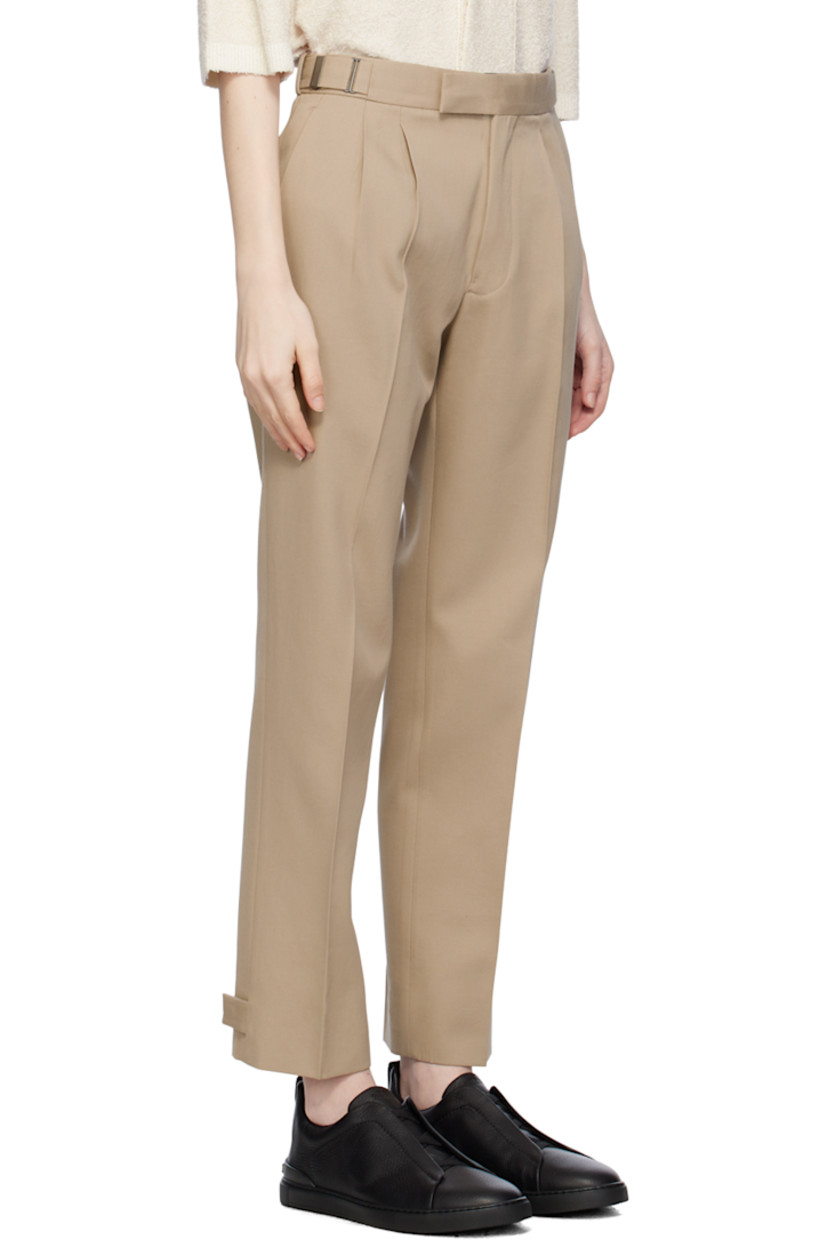Cotton- and wool-blend twill trousers. 

· High-rise
· Integrated cinch belt at waistband 
· Four-pocket styling
· Zip-fly
· Pleats at front waistband
· Central creases at front 
· Adjustable button tabs at cuffs 
· Partial cotton twill lining 

Supplier color: Beige