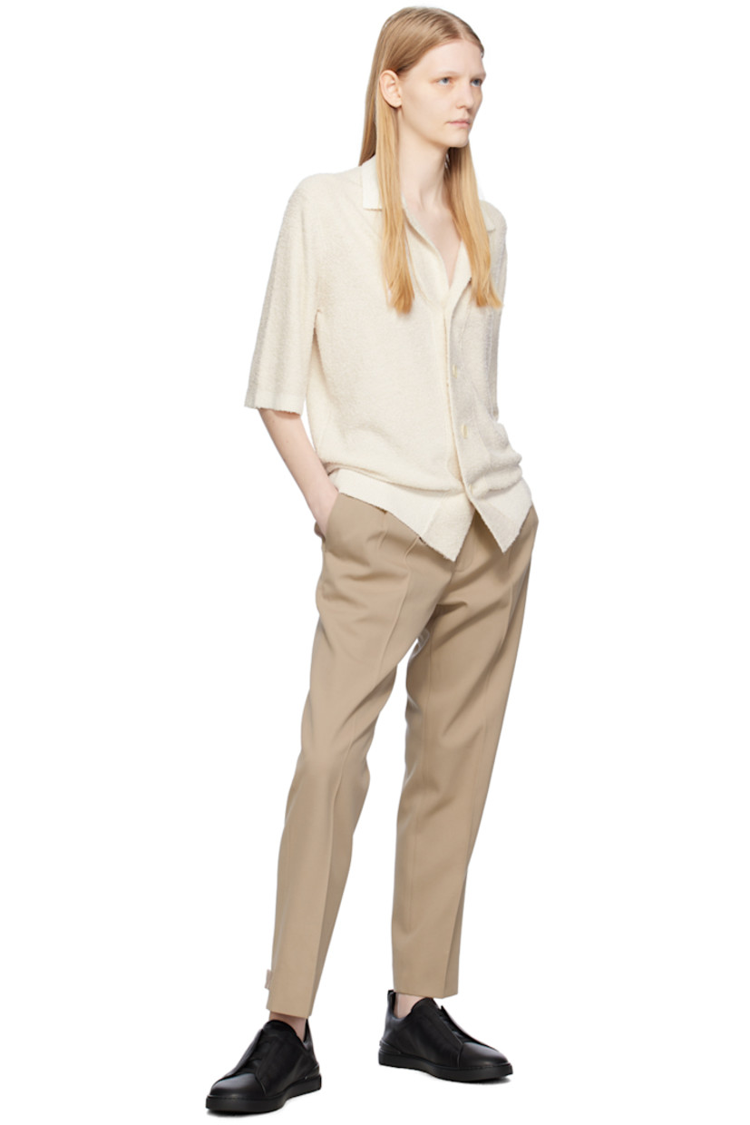 Cotton- and wool-blend twill trousers. 

· High-rise
· Integrated cinch belt at waistband 
· Four-pocket styling
· Zip-fly
· Pleats at front waistband
· Central creases at front 
· Adjustable button tabs at cuffs 
· Partial cotton twill lining 

Supplier color: Beige